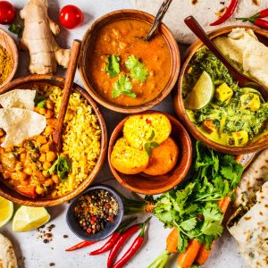 Food traditional Indian cuisine. Dal, palak paneer, cheese balls, curry, rice, chapati, chutney in wooden bowls on white background.