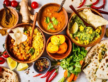 Food traditional Indian cuisine. Dal, palak paneer, cheese balls, curry, rice, chapati, chutney in wooden bowls on white background.