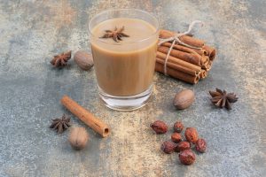 Cup of coffee with cinnamon sticks on marble background. High quality photo